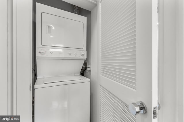 clothes washing area featuring stacked washing maching and dryer