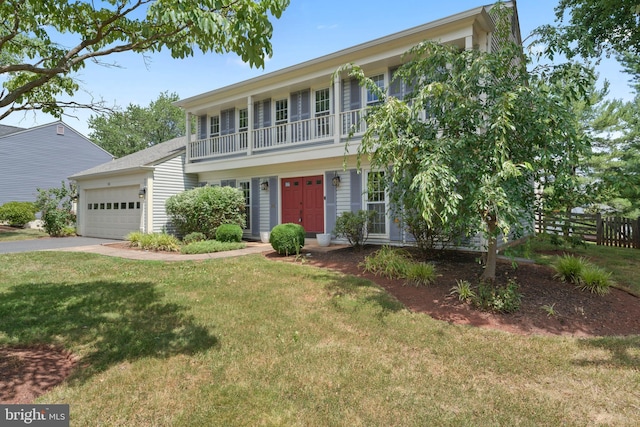 view of front of home with a balcony, a garage, and a front yard