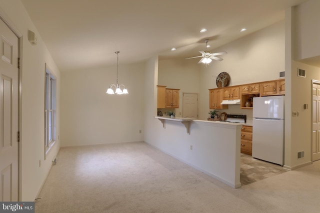 kitchen with pendant lighting, white fridge, a kitchen breakfast bar, kitchen peninsula, and stove