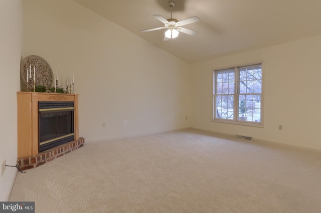 unfurnished living room with a brick fireplace, carpet, lofted ceiling, and ceiling fan