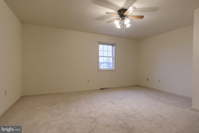 carpeted spare room featuring ceiling fan