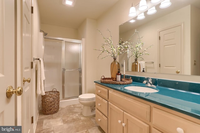 bathroom featuring vanity, toilet, and a shower with door