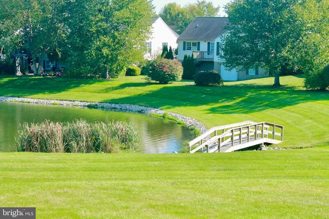 view of community with a water view and a lawn