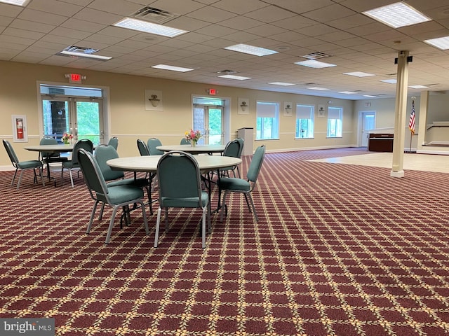 carpeted dining room featuring a paneled ceiling and french doors