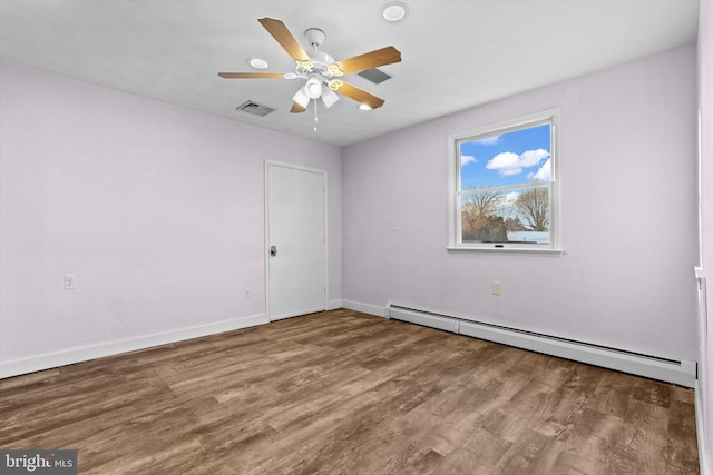 empty room featuring ceiling fan, hardwood / wood-style floors, and a baseboard heating unit