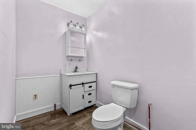 bathroom with wood-type flooring, toilet, and vanity