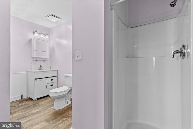 bathroom featuring a shower, wood-type flooring, toilet, and vanity