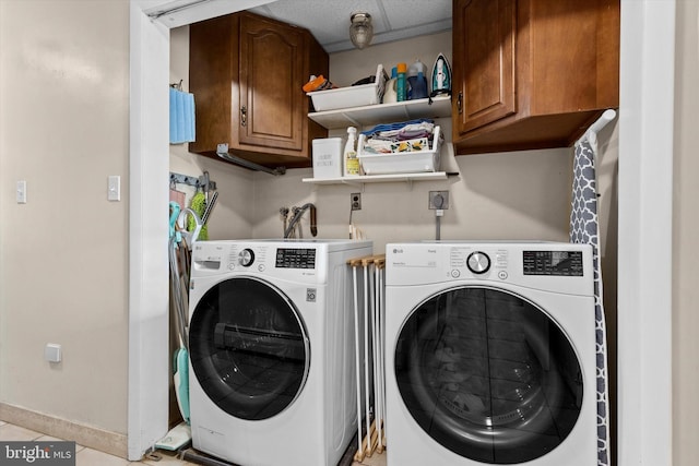 washroom with cabinets, light tile patterned floors, and washing machine and dryer