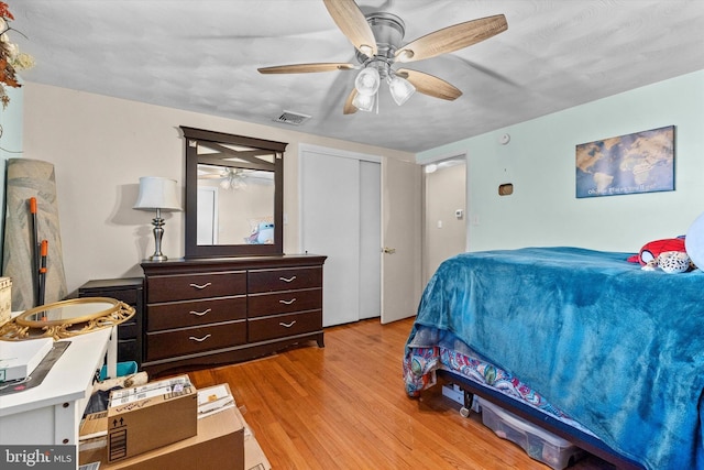 bedroom with ceiling fan, a closet, and light hardwood / wood-style floors