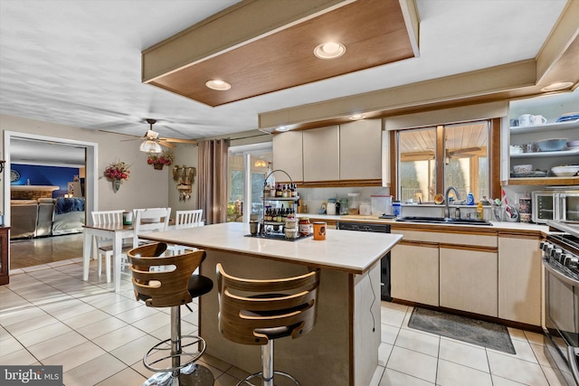 kitchen with a center island, sink, ceiling fan, stainless steel range with gas cooktop, and light tile patterned floors