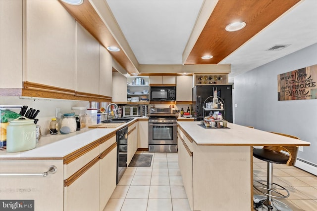 kitchen featuring a center island, black appliances, a breakfast bar, white cabinets, and light tile patterned floors