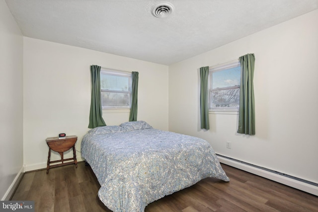bedroom featuring dark hardwood / wood-style floors and baseboard heating