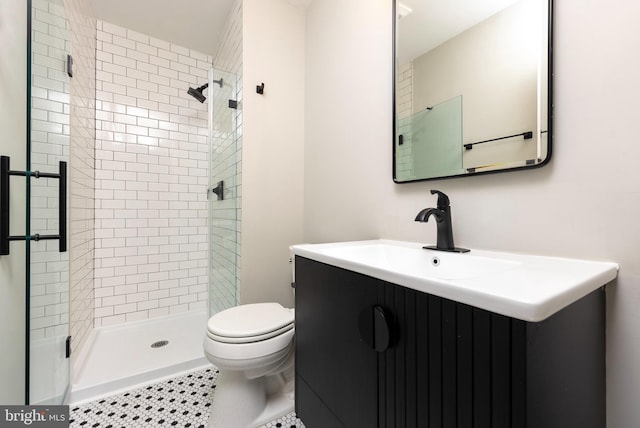 bathroom featuring vanity, a shower with shower door, and toilet