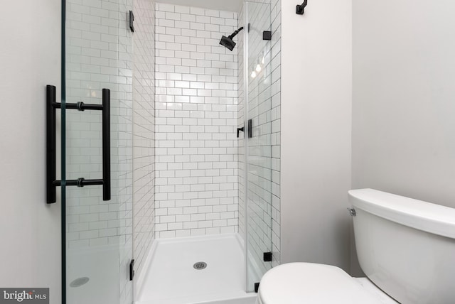 bathroom with toilet and a shower with shower door