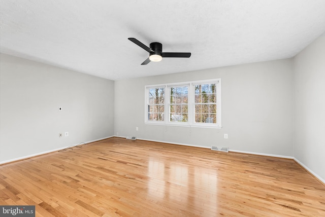 empty room featuring ceiling fan, light hardwood / wood-style floors, and a textured ceiling