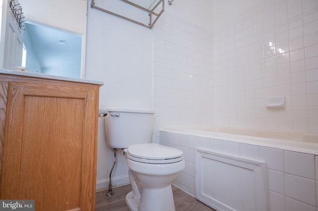 bathroom with wood-type flooring, toilet, and tiled shower / bath combo