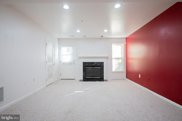 unfurnished living room with a fireplace and light colored carpet