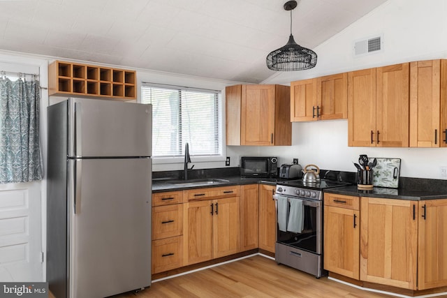 kitchen featuring vaulted ceiling, pendant lighting, sink, light wood-type flooring, and appliances with stainless steel finishes