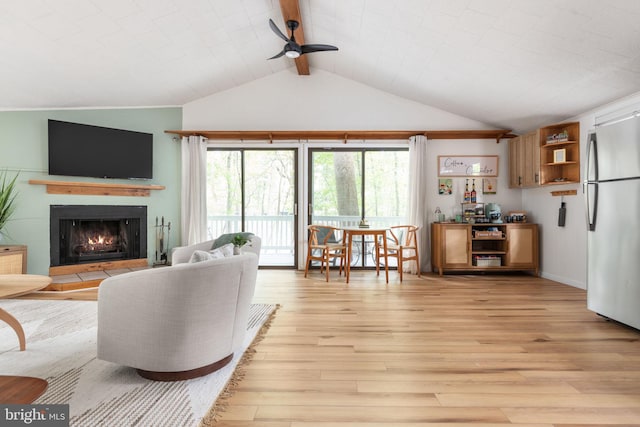 living room featuring ceiling fan, vaulted ceiling with beams, and light wood-type flooring