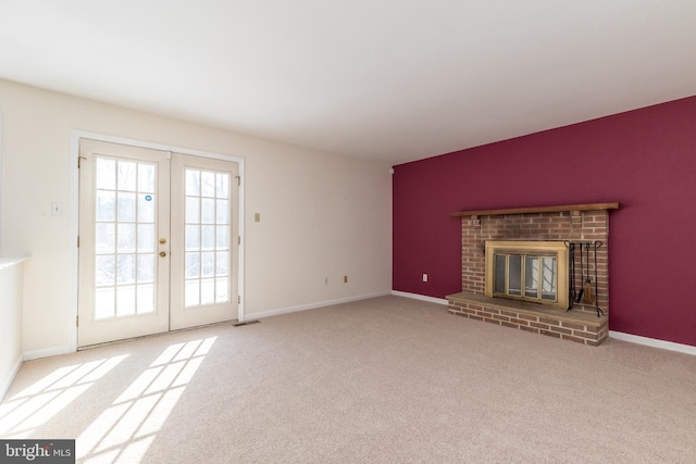 unfurnished living room with light carpet, a fireplace, and french doors