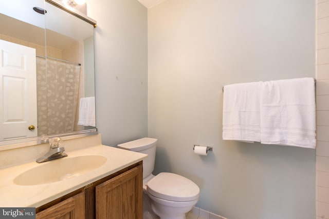 bathroom with vanity, toilet, and walk in shower