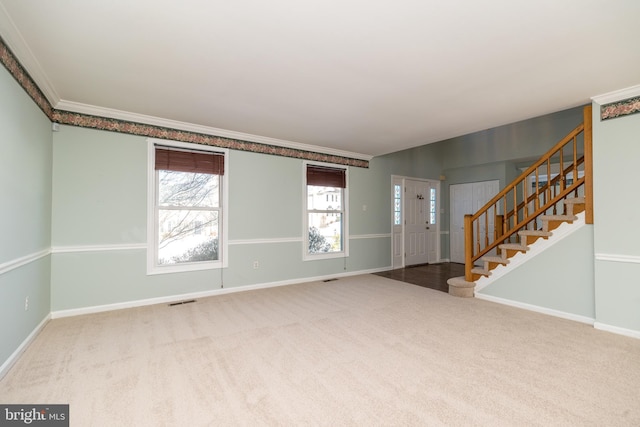 foyer entrance featuring ornamental molding and carpet floors