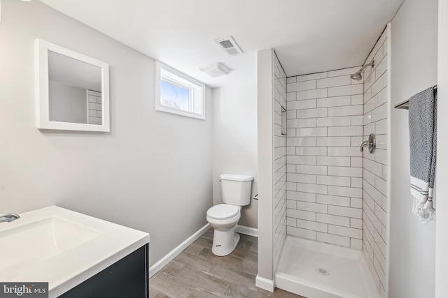 full bath featuring wood finished floors, visible vents, toilet, and tiled shower