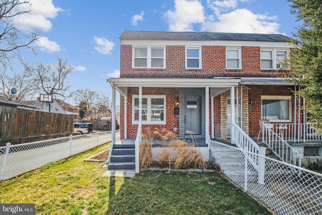 view of front of home featuring a porch, fence private yard, brick siding, and a front lawn