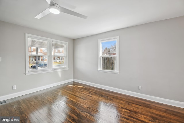 unfurnished room featuring wood-type flooring, visible vents, baseboards, and ceiling fan