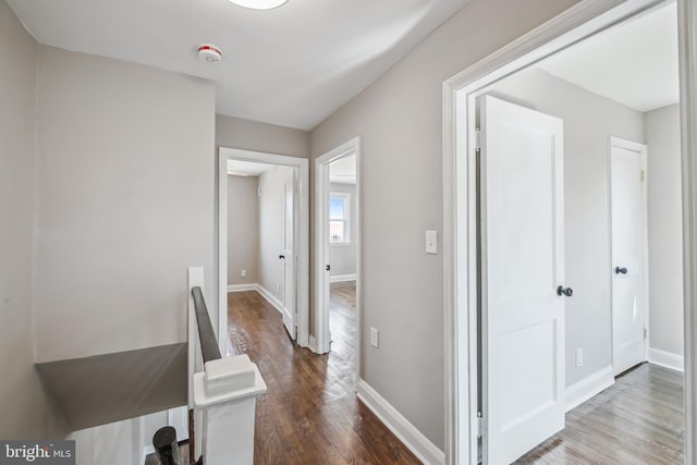 hall featuring baseboards and dark wood-style flooring