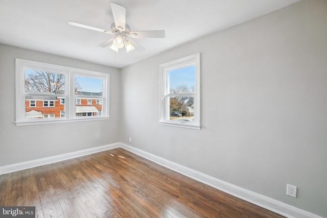 spare room with a ceiling fan, baseboards, and dark wood-style flooring