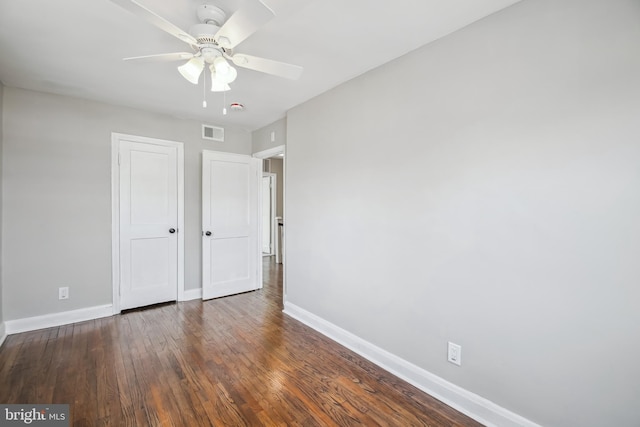 unfurnished bedroom featuring baseboards, visible vents, ceiling fan, wood finished floors, and a closet