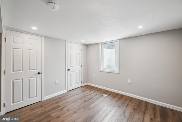 basement with baseboards, wood finished floors, and recessed lighting