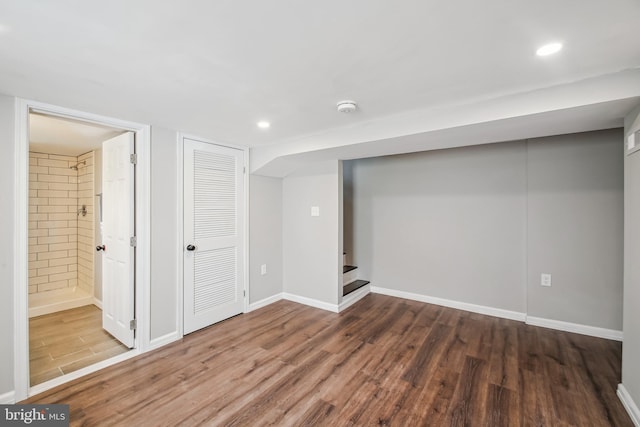 finished basement featuring stairs, baseboards, wood finished floors, and recessed lighting