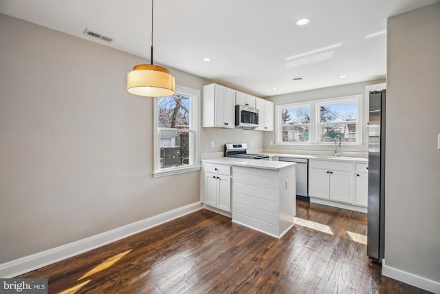 kitchen with white cabinetry, visible vents, baseboards, appliances with stainless steel finishes, and dark wood-style floors