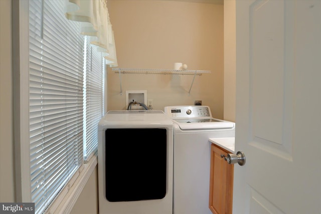 clothes washing area featuring a healthy amount of sunlight, independent washer and dryer, and cabinets