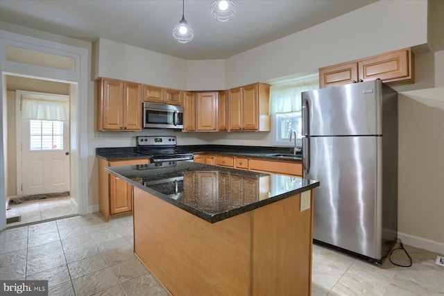 kitchen featuring appliances with stainless steel finishes, a center island, sink, hanging light fixtures, and plenty of natural light