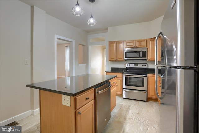 kitchen featuring stainless steel appliances, pendant lighting, dark stone countertops, and a kitchen island