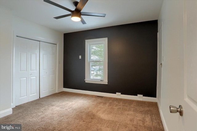 unfurnished bedroom with ceiling fan, a closet, and carpet floors