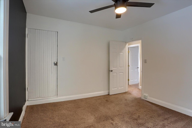 carpeted spare room with ceiling fan