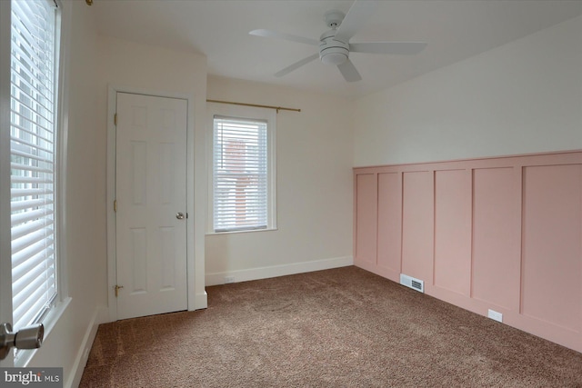 spare room featuring ceiling fan and carpet floors