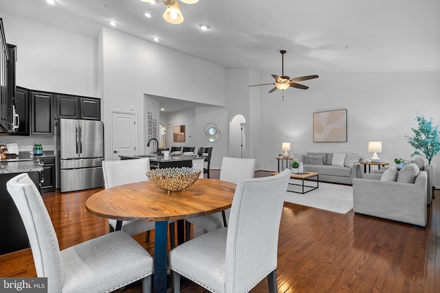 dining area with high vaulted ceiling, sink, dark hardwood / wood-style floors, and ceiling fan