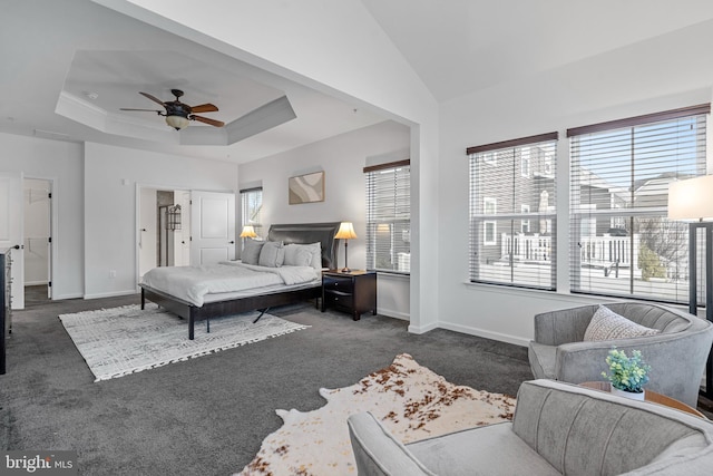 carpeted bedroom featuring ceiling fan and a raised ceiling