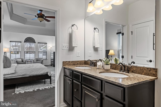 bathroom with vanity, ceiling fan, ornamental molding, and a tray ceiling