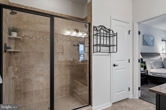 bathroom with a shower with shower door, vanity, and tile patterned flooring