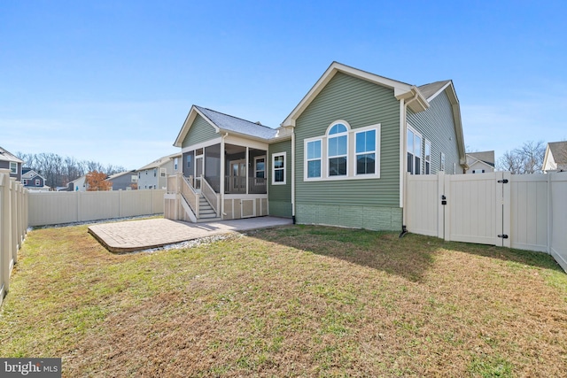 back of house with a sunroom, a lawn, and a patio