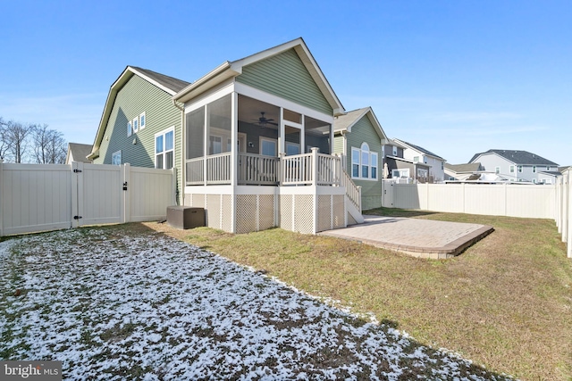 rear view of property featuring ceiling fan, a patio area, a yard, and a sunroom