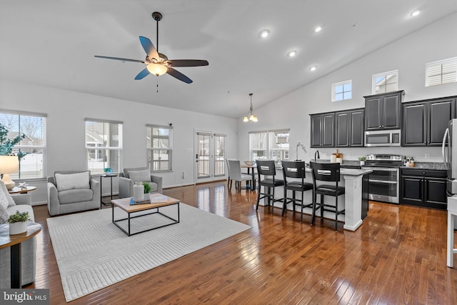 living room featuring ceiling fan, dark wood-type flooring, and high vaulted ceiling