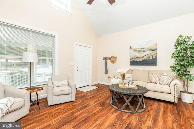 living room featuring dark wood-type flooring, ceiling fan, and a high ceiling