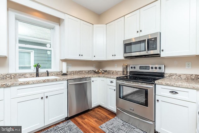 kitchen featuring white cabinetry, sink, stainless steel appliances, and dark hardwood / wood-style floors